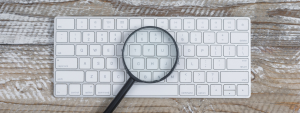 Couverture article référencement naturel ou payant avec un clavier et une loupe